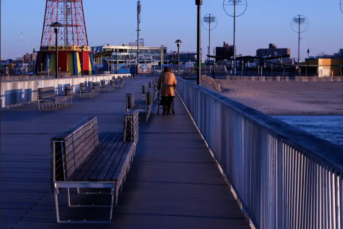 A photo of a woman walking on the Coney Island Boardway